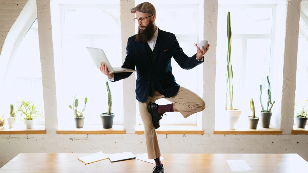B2B buyer standing on desk in office with his laptop